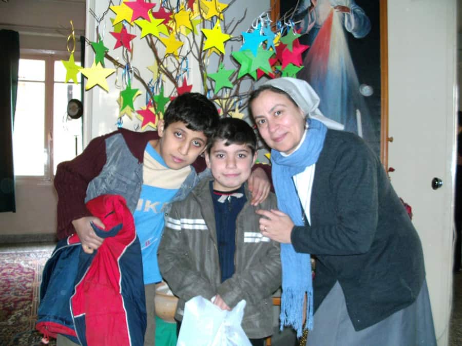 SYRIA / ALEP-CLD 15/00055
Christmas gift for the children and the people in Al Hassekeh and Aleppo, Christmas 2013: Sister Annie with two boys receiving a Christmas gift