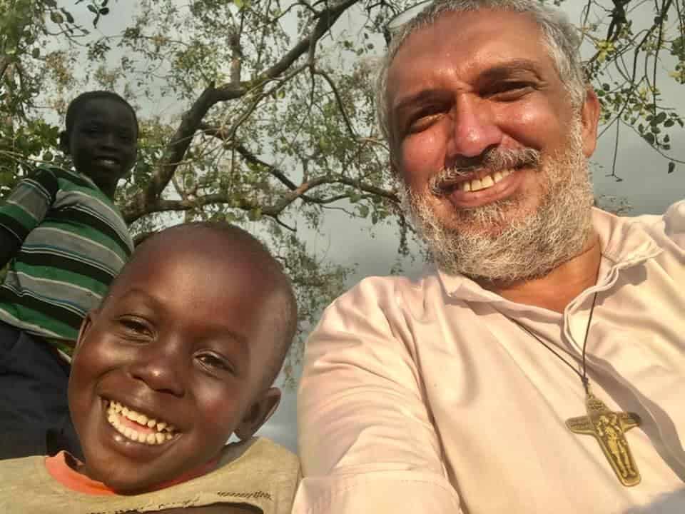 Padre Ube con niños en Palabek